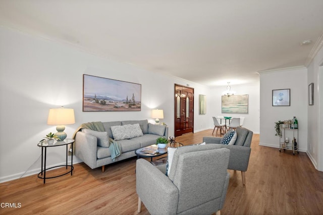 living room featuring wood-type flooring, crown molding, and a chandelier