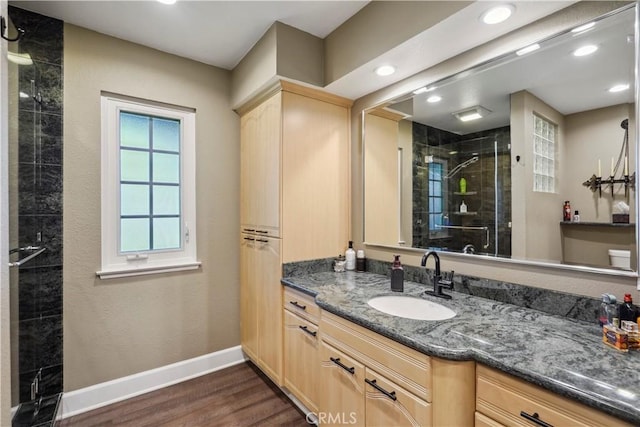 bathroom with wood-type flooring, walk in shower, and vanity