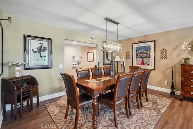 dining room featuring dark hardwood / wood-style flooring and an inviting chandelier