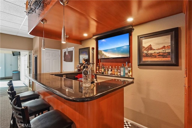 bar featuring pendant lighting and dark stone counters