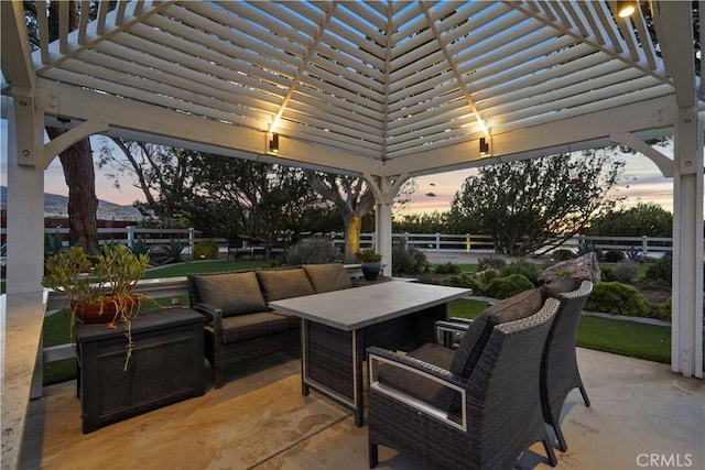 patio terrace at dusk with an outdoor hangout area and a pergola