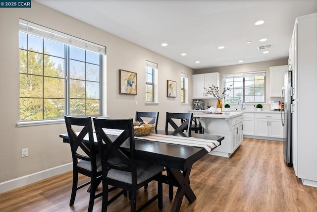 dining room featuring sink and light hardwood / wood-style flooring