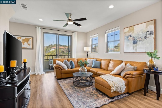 living room with ceiling fan and light wood-type flooring