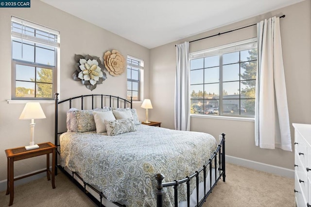 bedroom featuring light colored carpet and multiple windows