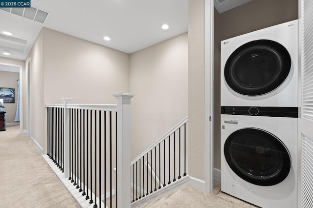 laundry area with light carpet and stacked washer / dryer