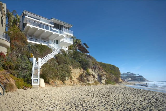 exterior space with a water view and a beach view