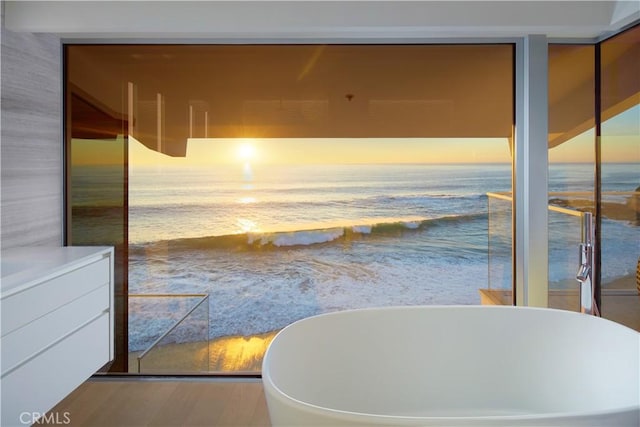 bathroom featuring a bath and a water view