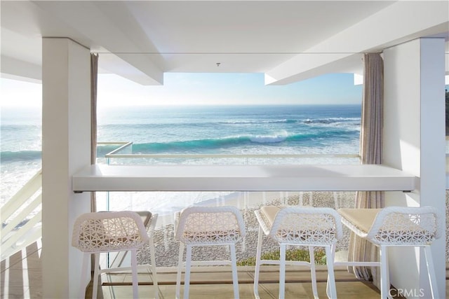 balcony with a water view and a beach view