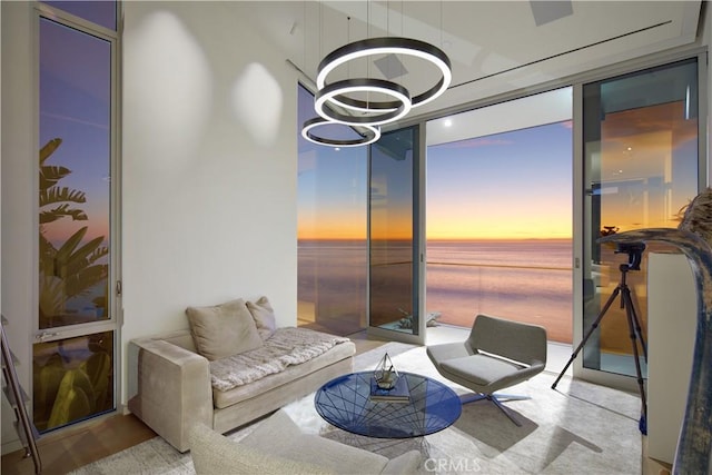 interior space featuring a water view, floor to ceiling windows, and a notable chandelier