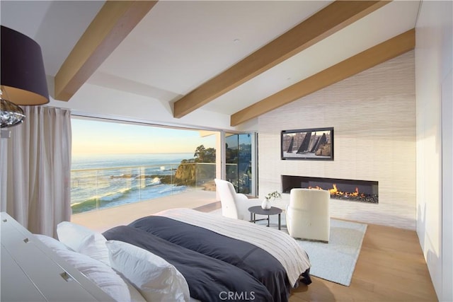 bedroom featuring vaulted ceiling with beams and light hardwood / wood-style flooring