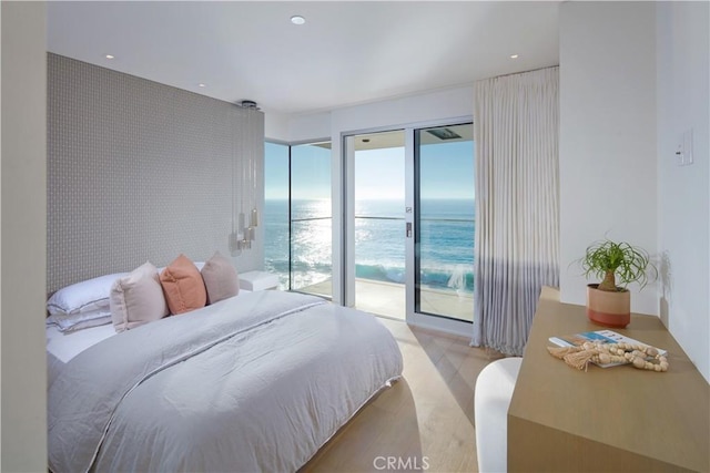 bedroom with a water view and access to exterior