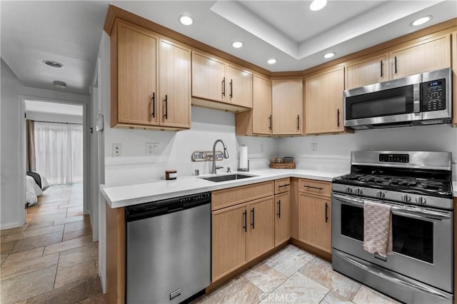 kitchen featuring appliances with stainless steel finishes, sink, and light brown cabinets