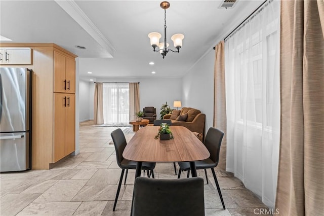 dining space with crown molding and an inviting chandelier