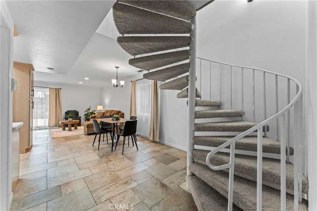 stairs with a chandelier