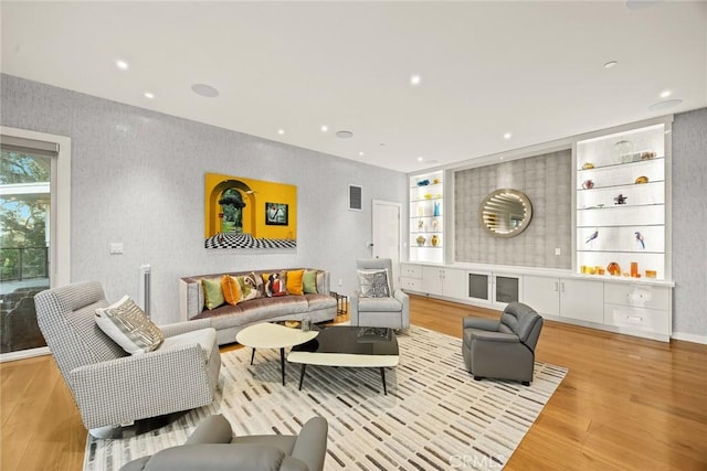 living room with light wood-type flooring and built in features