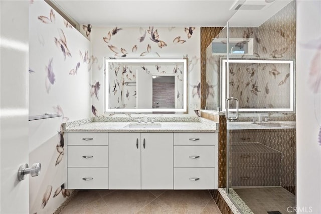 bathroom featuring tile patterned flooring, an enclosed shower, and vanity