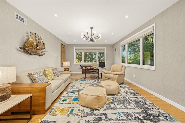 living room featuring an inviting chandelier and light hardwood / wood-style floors