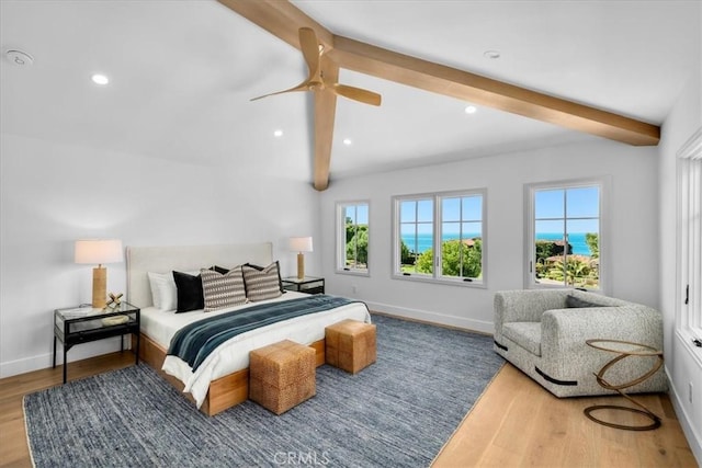 bedroom featuring ceiling fan, hardwood / wood-style floors, and vaulted ceiling with beams