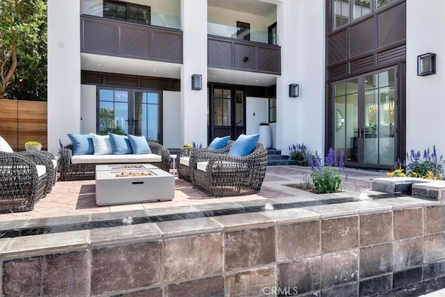 view of patio with an outdoor living space with a fire pit