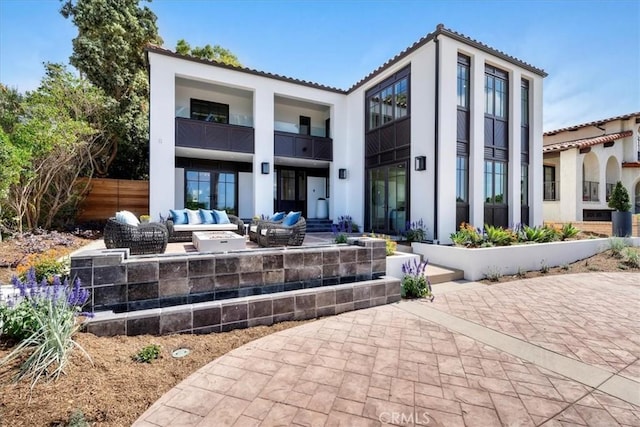 back of property with outdoor lounge area and a patio