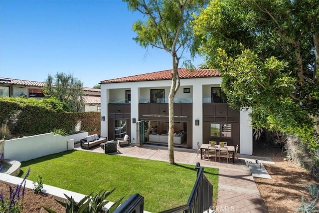 back of house with outdoor lounge area, a yard, and a patio area