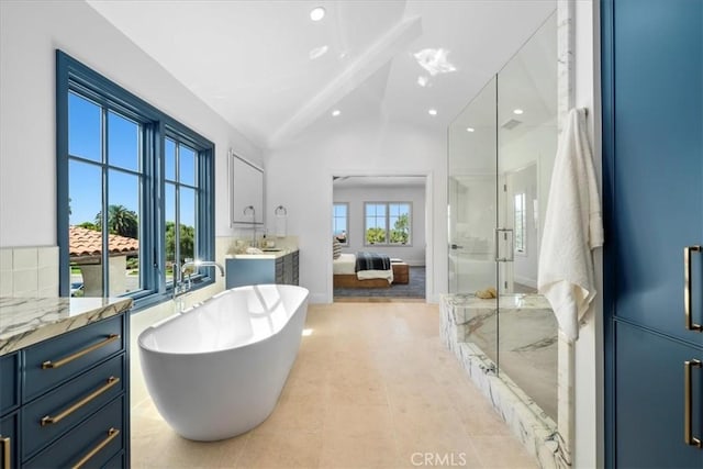 bathroom featuring vanity, a wealth of natural light, independent shower and bath, and vaulted ceiling