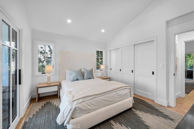 bedroom featuring dark hardwood / wood-style flooring, vaulted ceiling, and a closet