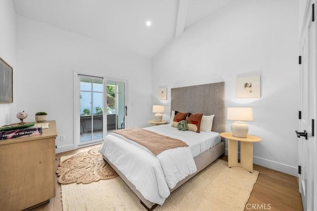 bedroom featuring high vaulted ceiling, access to outside, and light hardwood / wood-style floors