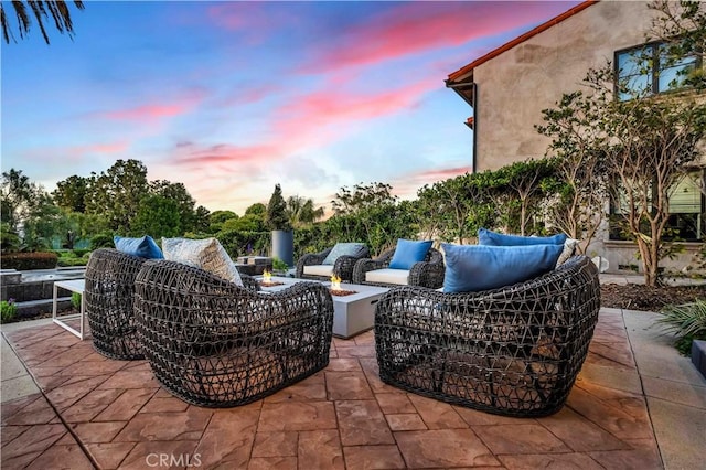 patio terrace at dusk featuring an outdoor living space with a fire pit