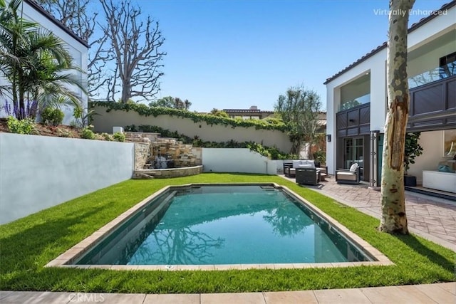 view of pool with a patio area and a lawn