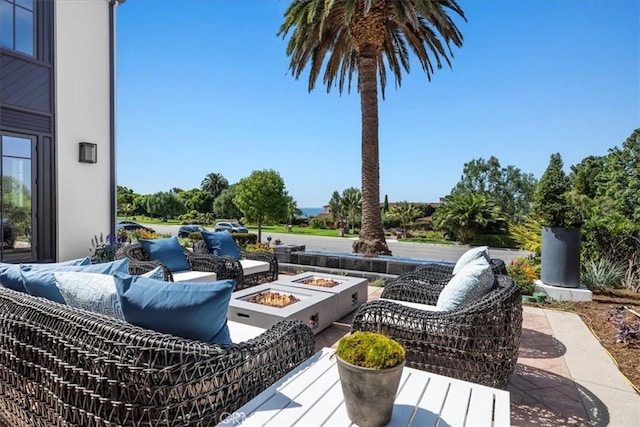 view of patio with an outdoor living space with a fire pit