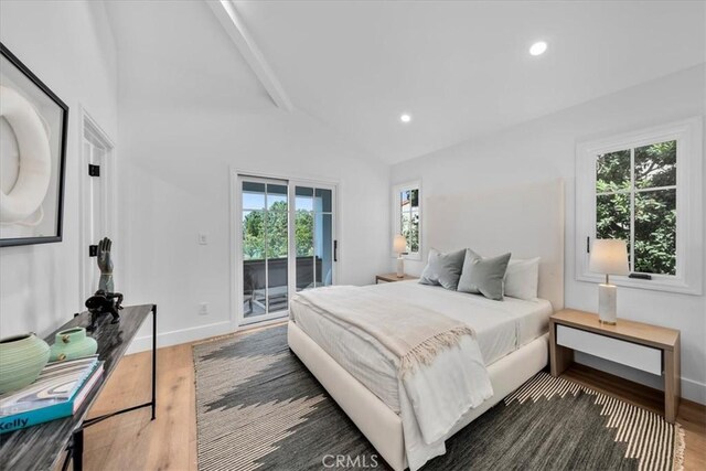 bedroom with dark hardwood / wood-style floors, high vaulted ceiling, and access to outside