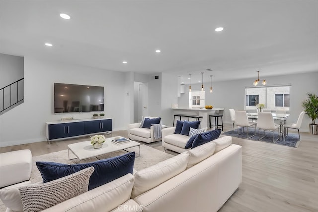 living room featuring a notable chandelier and light wood-type flooring