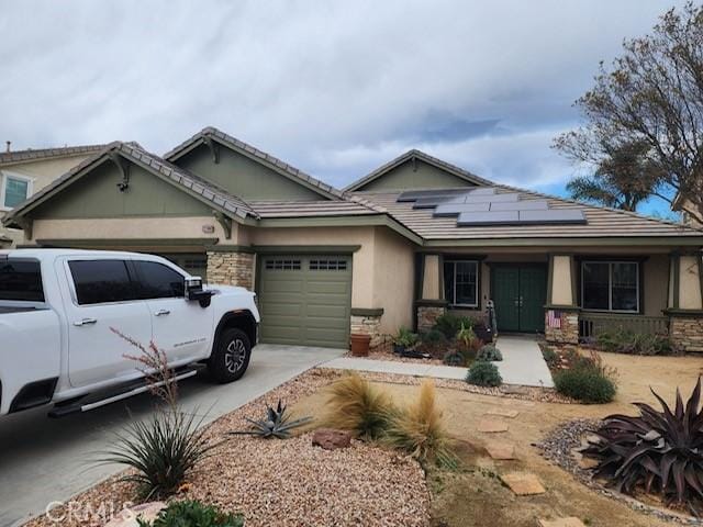 view of front facade featuring a garage and solar panels