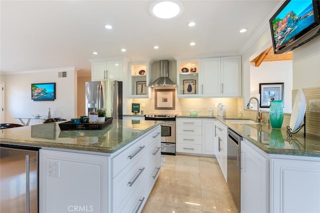 kitchen with sink, dark stone counters, white cabinetry, appliances with stainless steel finishes, and wall chimney exhaust hood