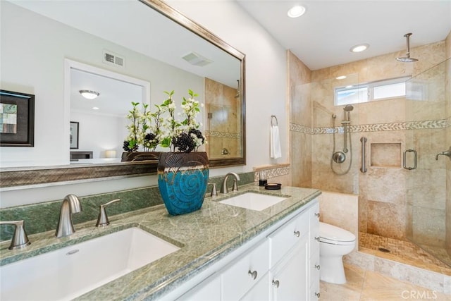 bathroom featuring a shower with shower door, tile patterned floors, toilet, and vanity