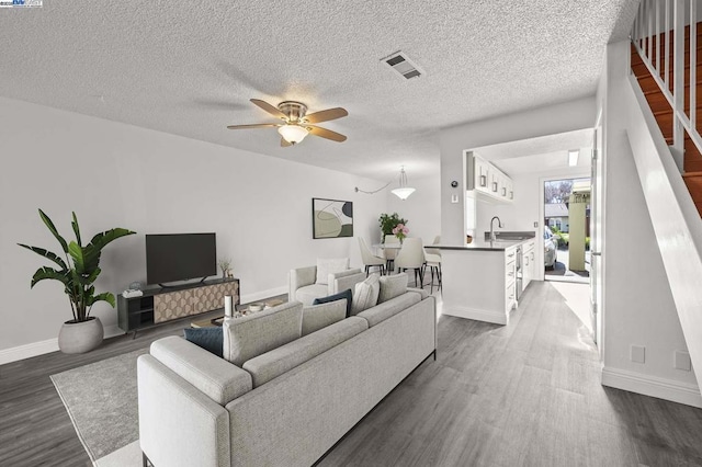 living room featuring ceiling fan, dark hardwood / wood-style floors, and sink