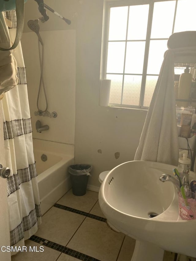 bathroom featuring toilet, tile patterned floors, and shower / bath combo with shower curtain