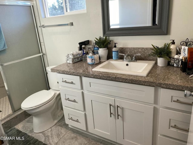 bathroom featuring toilet, a shower with shower door, and vanity