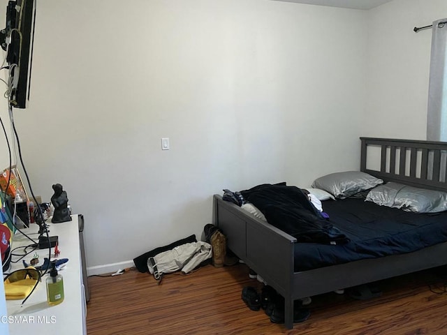 bedroom with dark wood-type flooring