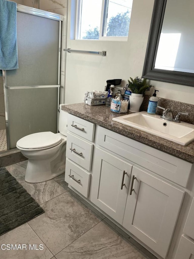 bathroom featuring an enclosed shower, vanity, and toilet