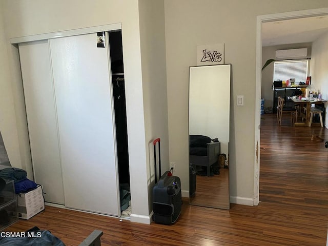 interior space featuring dark hardwood / wood-style flooring and an AC wall unit