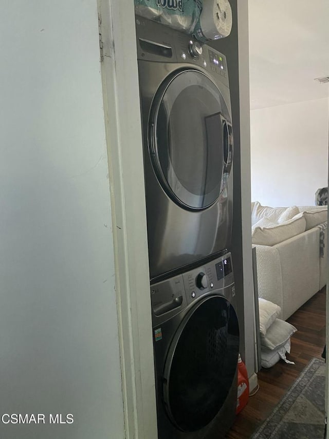 washroom with stacked washer and dryer and dark hardwood / wood-style floors