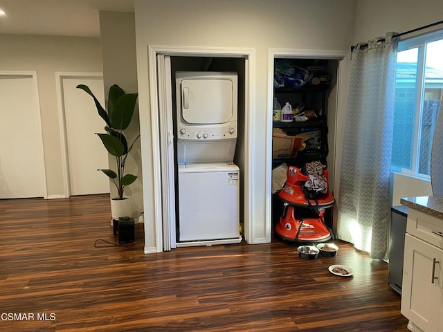 washroom with stacked washer and dryer and dark hardwood / wood-style floors