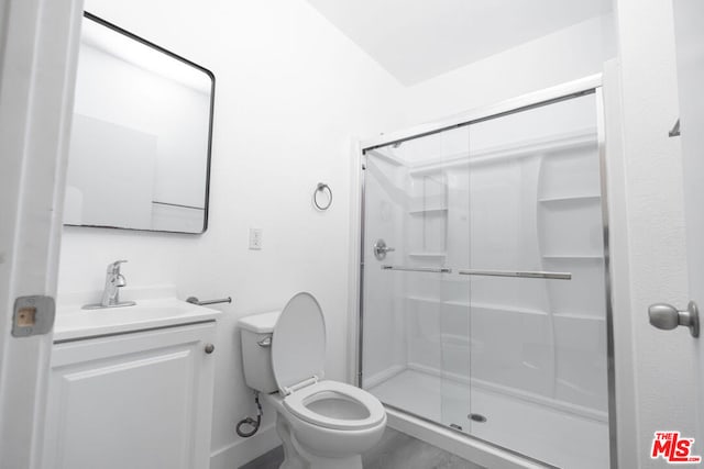 bathroom with vanity, a shower with shower door, and toilet