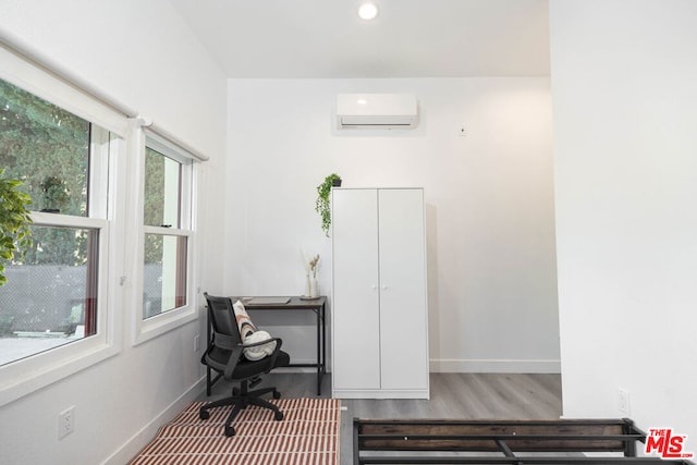 office featuring hardwood / wood-style flooring and an AC wall unit