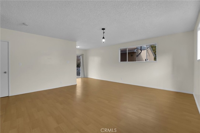 unfurnished room featuring hardwood / wood-style flooring and a textured ceiling