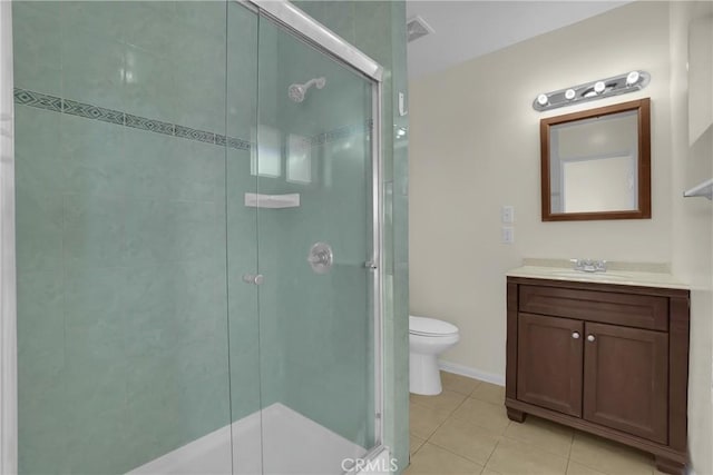 bathroom featuring toilet, tile patterned floors, a shower with shower door, and vanity