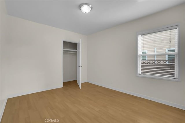 unfurnished bedroom featuring light wood-type flooring and a closet