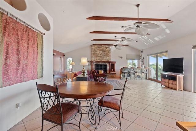 dining room featuring a fireplace, light tile patterned floors, and vaulted ceiling